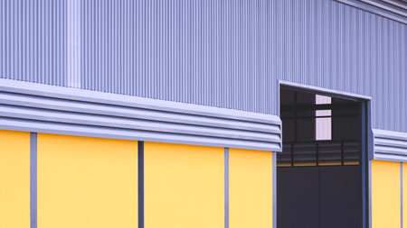 Entrance door of industrial factory building with yellow concrete and steel louver ventilation on gray aluminum corrugated wall in perspective side viewの写真素材