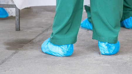 Feet of Healthcare Workers Covered with blue Protective Plastic Bags on the floor while working in public outdoor area during the COVID-19 outbreak, close up with copy spaceの写真素材