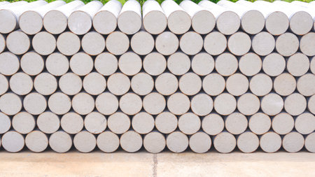 Concrete cylinder micropile background. Pile of many precast spun micropiles construction material...