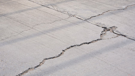Broken crack lines texture on the old damaged concrete street surface