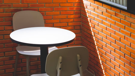 Round wooden coffee table set near brick wall inside of vintage coffee shop