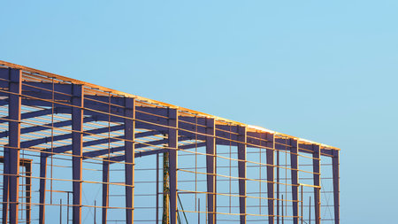 Factory industrial building framework with metal posts and roof beam structure in construction site...