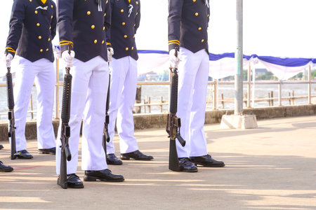 Cropped image of Thai navy group are standing with holding guns in a defensive stance gesture while performing a show in riverside area during the Royal Thai Armed Forces Dayの写真素材