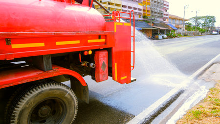Worker on fire truck spraying water into the road for reduce PM 2.5 dust levels problem in the air...