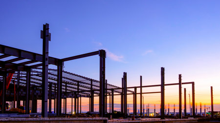Silhouette industrial factory building structure with metal columns and roof beam framework in...