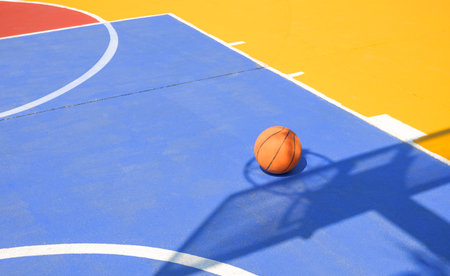 Basketball on outdoor basketball court with colorful outline pattern on concrete yard floor surface in high school, Sport field backgroundの写真素材