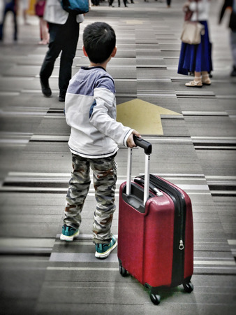 An asian boy traveller on holiday trip is going to the gate with his luggage.の写真素材