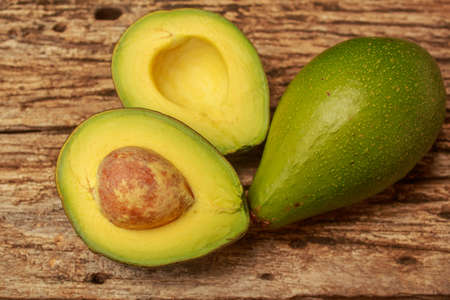 Avocado cut in half on old wood