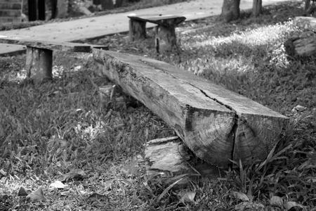 Old Wooden bench made of tree trunks in gardenの写真素材
