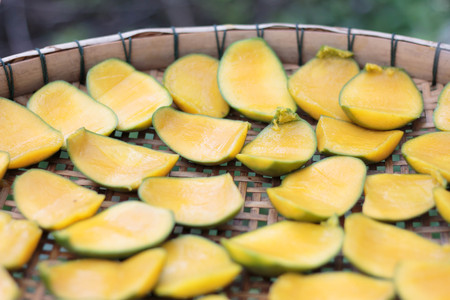 Dried Mango slices are placed on a bamboo mat.の写真素材