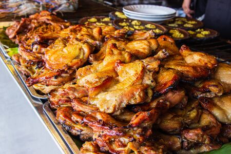Close-up Grilled chicken on aluminum tray for service the tourist inside restaurant. (selective focus)の写真素材