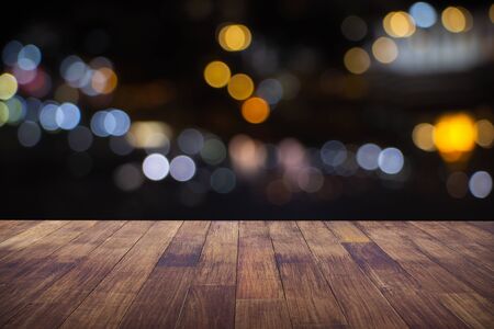 Blur cafe restaurant or coffee shop empty of dark wood table with blurred light gold bokeh abstract...