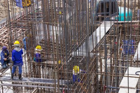 Construction workers fabricating large steel bar reinforcement bar at the in construction area building site.の写真素材