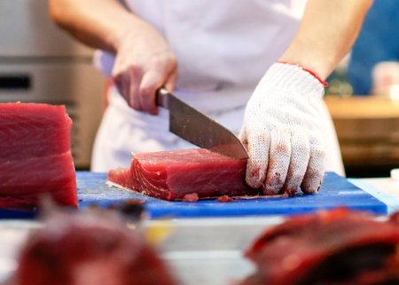 Chef cutting fresh tuna fish in the kitchenの写真素材