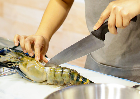chef cooking seafood, Hand cutting raw black tiger prawnの写真素材