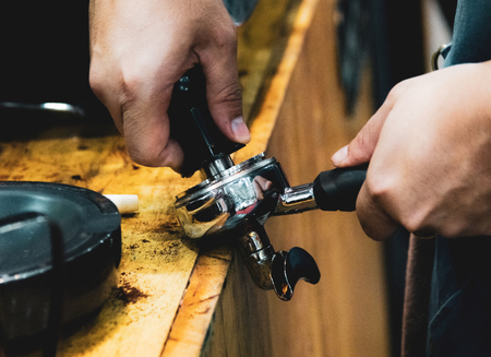 Barista working in a coffee shop, Close up of barista presses ground coffee using tamper, Barista Make Coffee Portafilter Conceptの写真素材