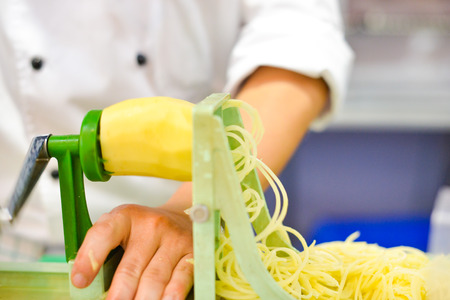 Vegetable Blade Spiralizer, Spiral vegetable slicer with potato spaghetti on tableの写真素材