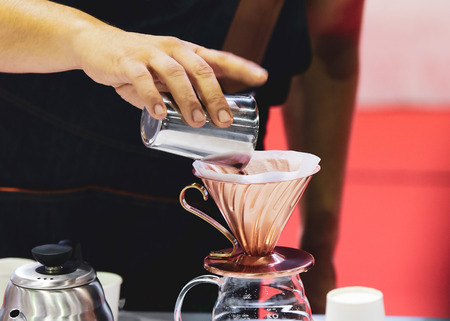 Barista is making coffee, coffee preparing with coffee dripper, Dripping hot fresh coffeeの写真素材