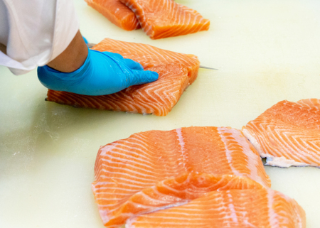 chef slicing raw fresh salmon, Chef preparing a fresh salmon on a cutting boardの写真素材