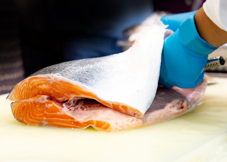 chef slicing raw fresh salmon, Chef preparing a fresh salmon on a cutting boardの写真素材