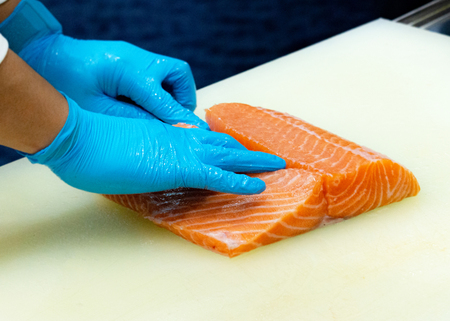 chef slicing raw fresh salmon, Chef preparing a fresh salmon on a cutting boardの写真素材