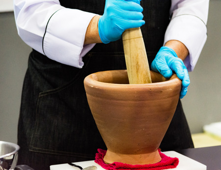 Using a mortar and pestle to pound ingredients for thai food, Pound mortarの写真素材
