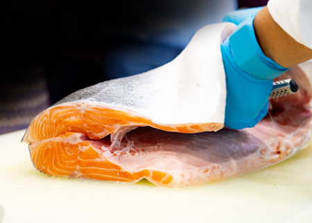 chef slicing raw fresh salmon, Chef preparing a fresh salmon on a cutting boardの写真素材