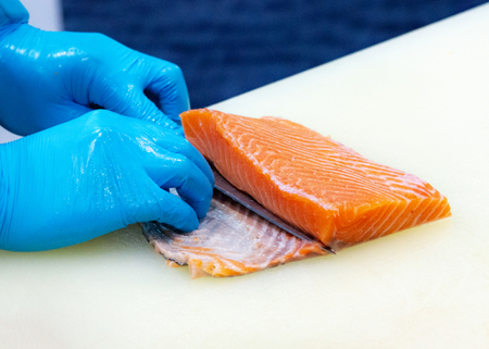 chef slicing raw fresh salmon, Chef preparing a fresh salmon on a cutting boardの写真素材
