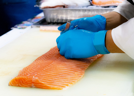 chef slicing raw fresh salmon, Chef preparing a fresh salmon on a cutting boardの写真素材