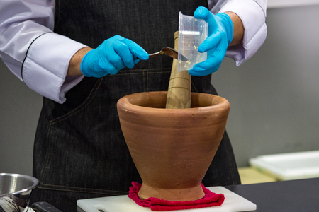 Using a mortar and pestle to pound ingredients for thai food, Pound mortarの写真素材
