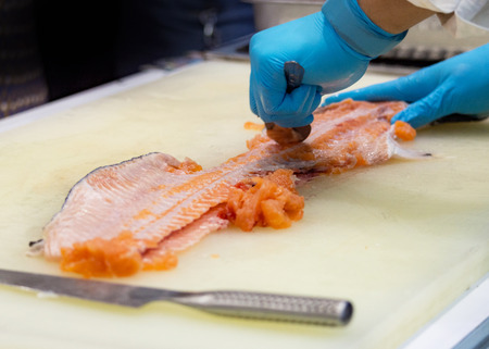 chef slicing raw fresh salmon, Chef preparing a fresh salmon on a cutting boardの写真素材