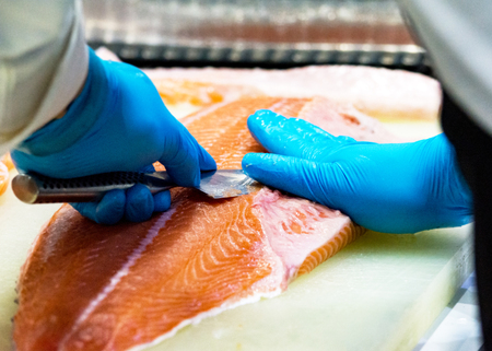 chef slicing raw fresh salmon, Chef preparing a fresh salmon on a cutting boardの写真素材