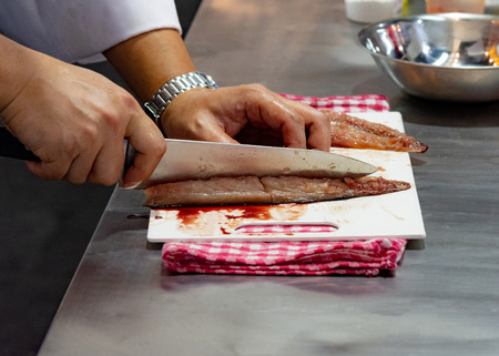 Chef cutting fish, Chef slices fish fresh on Board in the kitchen