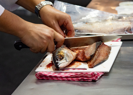 Chef cutting fish, Chef slices fish fresh on Board in the kitchenの写真素材