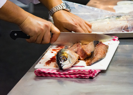 Chef cutting fish, Chef slices fish fresh on Board in the kitchenの写真素材