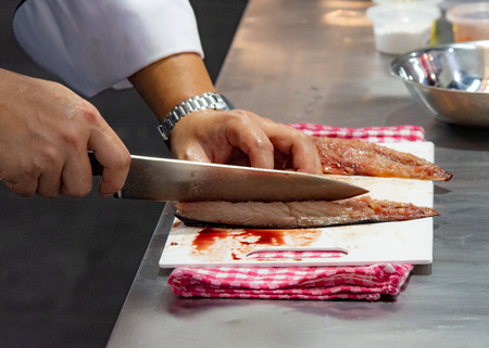 Chef cutting fish, Chef slices fish fresh on Board in the kitchenの写真素材