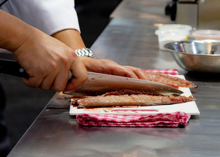 Chef cutting fish, Chef slices fish fresh on Board in the kitchenの写真素材