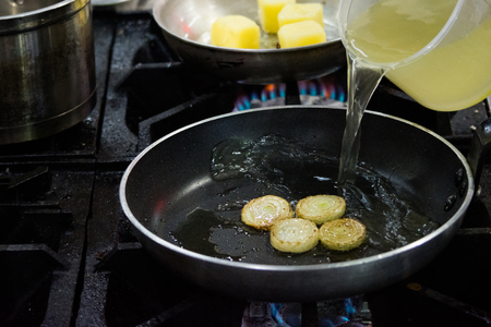 Chef cooking food in the kitchen, stir fried vegetables in the panの写真素材