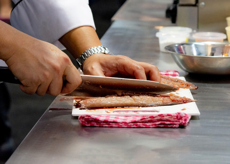 Chef cutting fish, Chef slices fish fresh on Board in the kitchenの写真素材