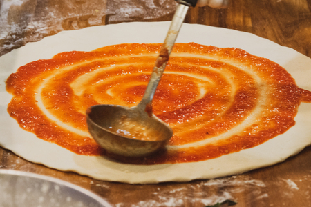 chef prepares delicious pizza on the kitchenの写真素材