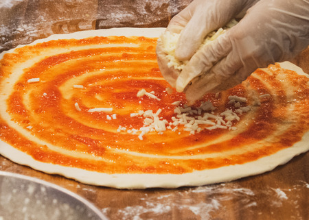 chef prepares delicious pizza on the kitchenの写真素材