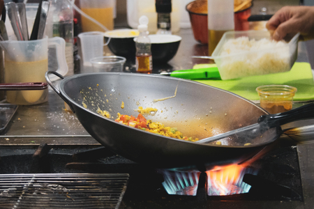 Chef cooking with flame in a frying pan on a kitchen stove, Chef in restaurant kitchen at stove with panの写真素材