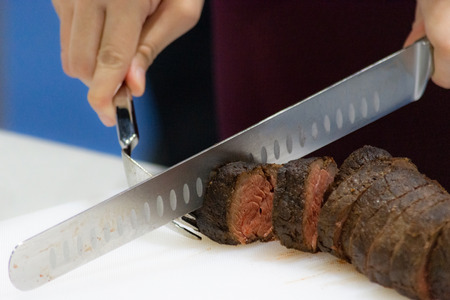 Roast beef and slice, chef's hands cutting roast beef, Carving roast beefの写真素材