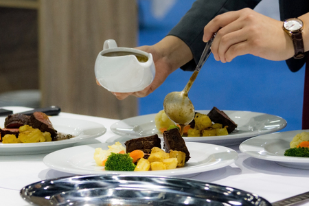 Decorating The Food In The Restaurant, Waiter is working on finishing a dish, diner waiter sandwichesの写真素材