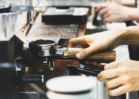 Barista working in a coffee shop, Close up of barista presses ground coffee using tamper, Barista Make Coffee Portafilter Conceptの写真素材