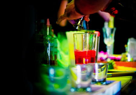 Bartender making alcohol cocktail at bar counter at nightclub, barman is making cocktailの写真素材