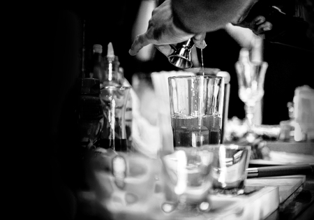 Bartender making alcohol cocktail at bar counter at nightclub, barman is making cocktailの写真素材