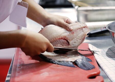 Chef cutting fish, Chef slices fish fresh on Board in the kitchen