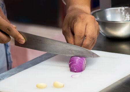 Chef is slicing fresh vegetable, Closeup of hands with knife cutting fresh organic vegetableの写真素材
