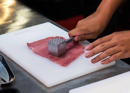Tenderize meat slice, Chef preparing meal in the kitchenの写真素材